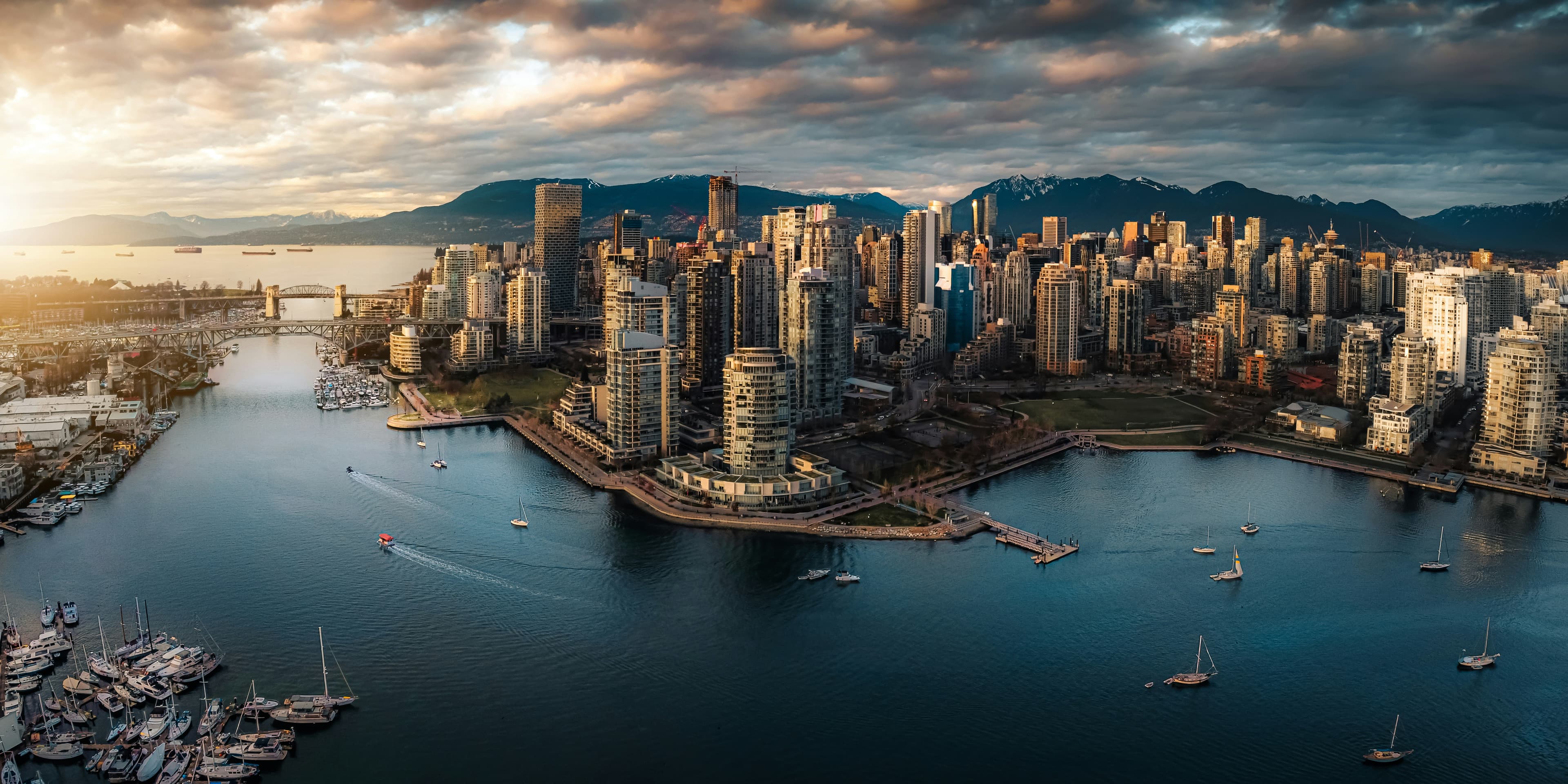 Ariel shot of False Creek with the towers of vancouver in the front and the mountains in behind
