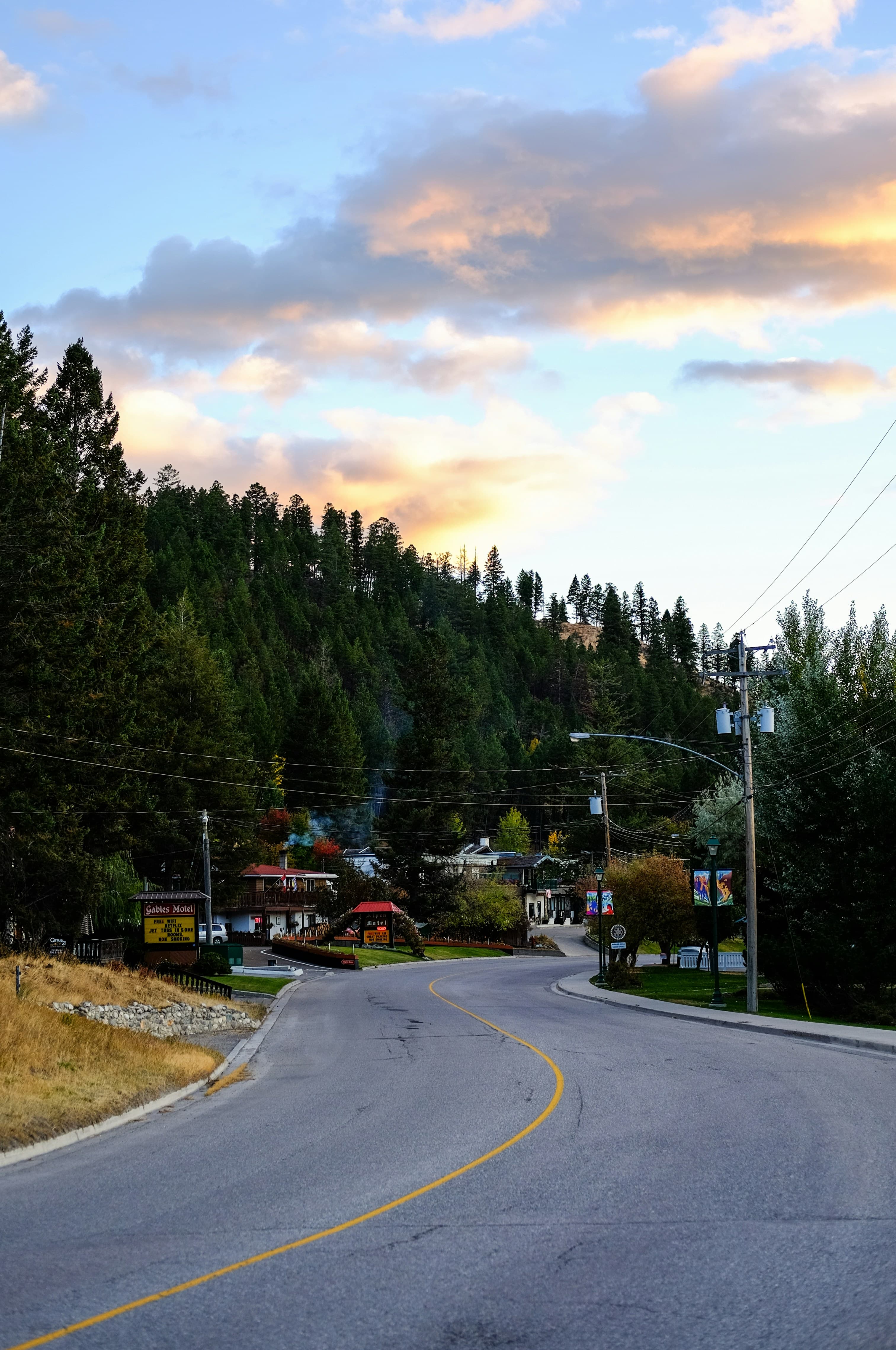 empty road at sunset with shops in the distance