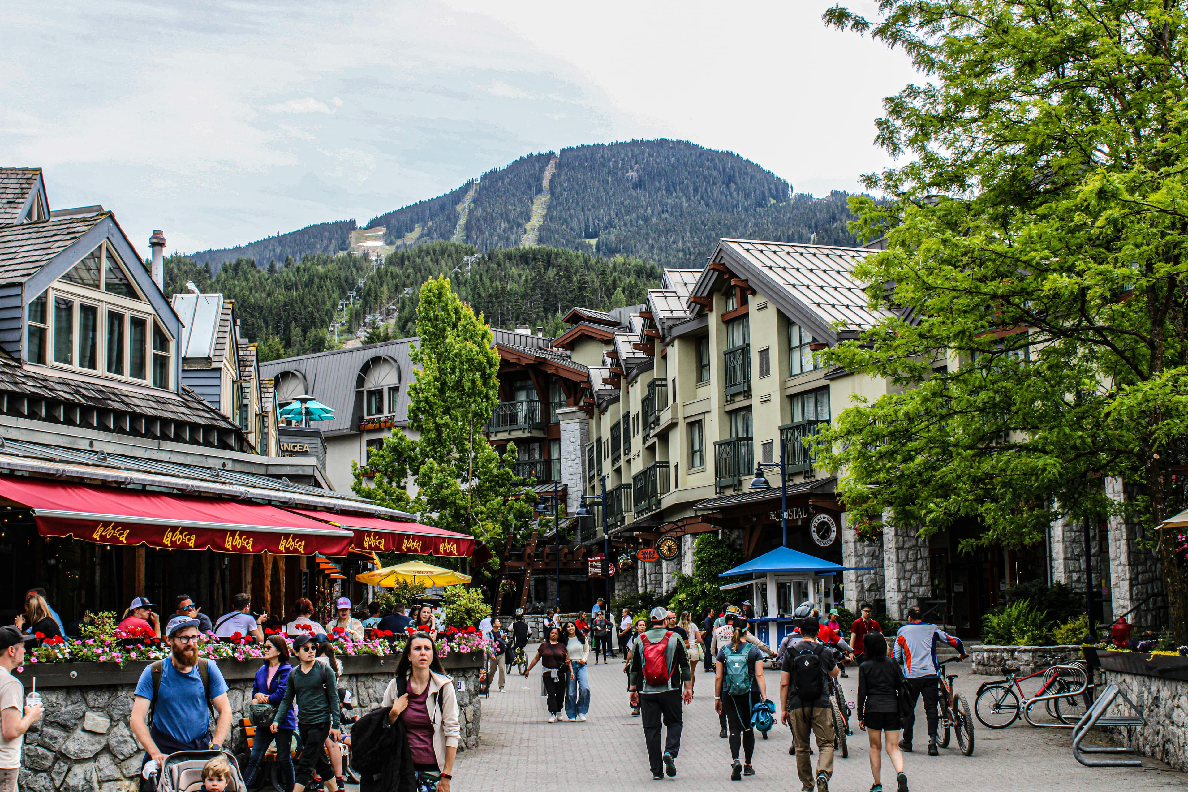 Busy downtown village in Whistler with mountains in the background